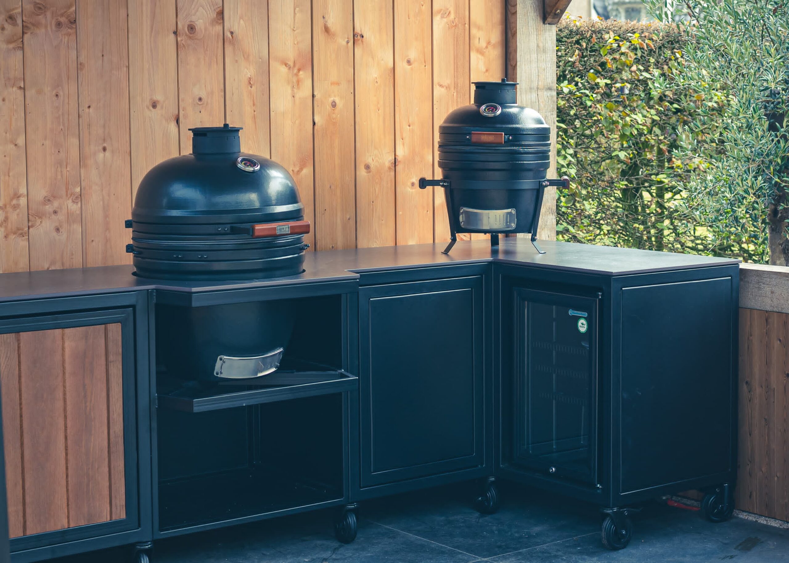 Blaue Outdoorküche mit Kamado-Grill auf einer Terrasse